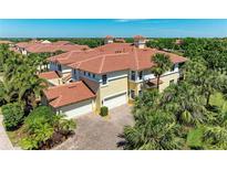 Expansive Mediterranean-style home with a red tile roof and attached two-car garage, surrounded by lush landscaping at 9429 Discovery Ter # 102B, Bradenton, FL 34212