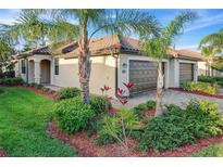Charming home with a three-car garage, lush landscaping, and a beautiful tiled roof, perfect for curb appeal at 12091 Amica Loop, Venice, FL 34293