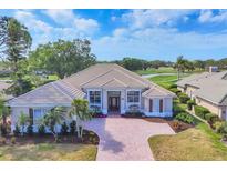 Stunning single-story home with a tile roof, brick driveway, and beautiful landscaping at 2020 Calusa Lakes Blvd, Nokomis, FL 34275