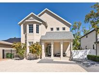 Charming two-story home with landscaped yard and inviting front porch sitting area at 2159 Hawthorne St, Sarasota, FL 34239