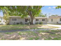 Charming single-story home with a large tree providing shade in the front yard at 218 80Th N Ave, St Petersburg, FL 33702