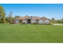 Charming single-story home featuring a manicured lawn, stone accents, and a welcoming front entrance at 4012 Twin Rivers Trl, Parrish, FL 34219