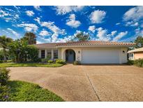 Charming single-story home boasts a red tile roof, arched doorway, and a beautifully landscaped front yard at 412 Giovanni Dr, Nokomis, FL 34275
