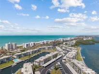 Stunning aerial view of a coastal community with water access, beaches, and manicured landscaping at 4390 Exeter Dr # 206, Longboat Key, FL 34228