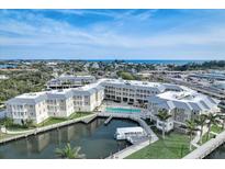 Beautiful aerial view of the resort-style condo complex with water access, a pool, and stunning views at 5325 Marina Drive # 423, Holmes Beach, FL 34217