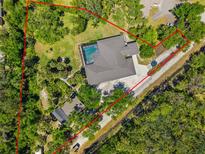 Stunning aerial view of the expansive property with a sparkling pool surrounded by lush landscaping and a well-defined perimeter at 5442 Kent Rd, Venice, FL 34293