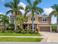 Stunning two-story home featuring lush tropical landscaping and an attached two-car garage at 5742 Hydrangea Cir, Sarasota, FL 34238