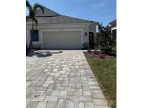 Charming one-story home featuring a two-car garage, manicured lawn, and inviting curb appeal at 7608 Registrar Way, Sarasota, FL 34243
