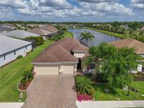 Beautiful aerial view of a two-story home, three car garage, landscaping and large pond at 1017 Siberian Glen, Bradenton, FL 34212