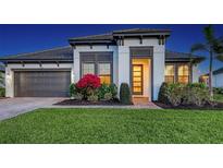 Charming one-story home showcasing a well manicured lawn and colorful landscaping at dusk at 11606 Apple Tree Cir, Bradenton, FL 34211