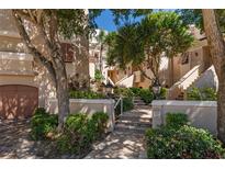 Inviting exterior of a multi-story building with lush landscaping and classic architectural details, creating a welcoming atmosphere at 1163 Coquille St # 207, Sarasota, FL 34242