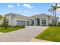 Charming one-story home with a three-car garage, a tile roof, a paved drive and beautiful landscaping at 12557 Galapagos Ct, Venice, FL 34293