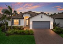 Beautiful home with a two-car garage, a tile roof, nice landscaping, and attractive exterior paint at 20892 Cattail Blvd, Venice, FL 34292