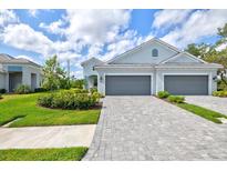 Charming single-Gathering home featuring a paver driveway, manicured lawn, and two-car garage at 2894 Butterfly Jasmine Trl, Sarasota, FL 34240