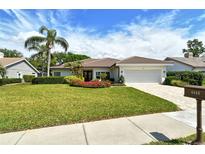 Beautiful one-story home with a well-manicured lawn and a two-car garage at 4444 Highland Oaks Cir, Sarasota, FL 34235