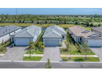 New construction homes showing the community's appealing landscaping, brick-paved driveways, and serene water view at 6260 Fish Eagle Ct, Nokomis, FL 34275