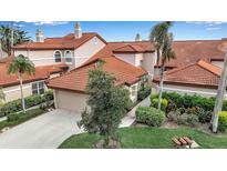 Charming home featuring a terracotta-tiled roof, lush landscaping, and a two-car garage at 7309 Regina Royale Blvd # 21, Sarasota, FL 34238