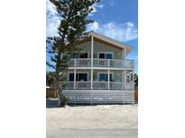 Charming two-story beach house featuring double balconies with white railings and coastal design elements at 1107 Shore View Dr, Englewood, FL 34223