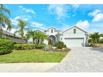 Charming single-story home featuring lush landscaping, a paver driveway, and a welcoming front entrance at 11723 Cullen Park Ter, Bradenton, FL 34211