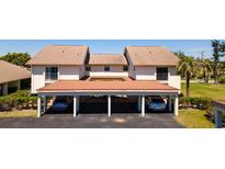 Inviting condominium featuring a covered parking area and meticulously maintained landscaping at 1770 Lake Pl # 1770D, Venice, FL 34293
