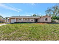 Charming single-story home featuring a well-maintained lawn and mature landscaping, located on a sunny lot at 2916 Woodcrest Dr, Sarasota, FL 34239