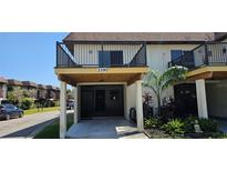 Inviting two-story condo features a covered parking area and quaint landscaping at 3390 Ramblewood Ct, Sarasota, FL 34237