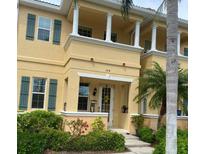 Inviting two-story home with lush landscaping, a covered entry, and charming architectural details at 3736 82Nd Avenue E Cir # 104, Sarasota, FL 34243