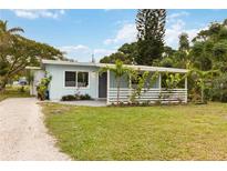 Charming home with light blue siding, white trim, covered porch, and a well-maintained front yard at 4111 Rockefeller Ave, Sarasota, FL 34231