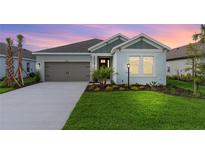 Charming single-story home boasting a well-manicured lawn, two-car garage, and inviting curb appeal at sunset at 4240 Pond Brook Ct, Bradenton, FL 34211