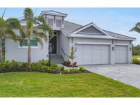 Charming gray home with a well-manicured lawn and lush landscaping at 5203 Title Row Dr, Bradenton, FL 34210