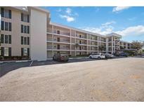 Residential condo building exterior with ample parking and manicured lawn at 7461 W Country Club N Dr # 207, Sarasota, FL 34243