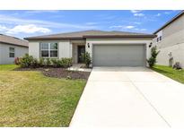 Charming one-story home featuring a well-maintained front yard and an attached two-car garage at 9215 Royal River Cir, Parrish, FL 34219