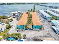 Aerial view of coastal apartments with bridge in background, ample parking, and tidy landscaping at 117 7Th N St # 14, Bradenton Beach, FL 34217