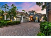Stunning two-story home with a three car garage, beautiful landscaping, and a brick driveway at 15024 Castle Park Ter, Lakewood Ranch, FL 34202