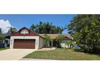 Charming single-story home with a well-manicured lawn, mature trees, and a two-car garage at 2385 Tall Oak Ct, Sarasota, FL 34232