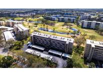 Stunning aerial view of the condo building overlooking a lush golf course with ponds and mature trees at 3620 Ironwood Cir # 606, Bradenton, FL 34209