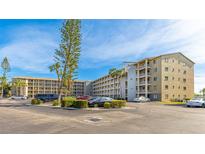 A multi-story residential building boasts well-maintained landscaping and ample parking at 3763 Lake Bayshore Dr # 310, Bradenton, FL 34205