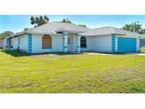 Inviting single-story home with a well-manicured lawn and bright blue garage door at 4404 5Th W Ave, Palmetto, FL 34221