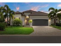 Charming single-story home with a tile roof, a lush lawn, and elegant landscaping with palm trees in a well-maintained community at 5811 Brandon Run, Bradenton, FL 34211