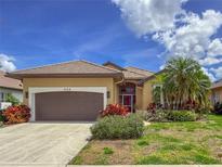 Charming single-story home features a tile roof, two-car garage, and well-maintained landscaping at 686 Silk Oak Dr, Venice, FL 34293
