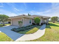 Well-maintained home featuring a two-car garage and lush landscaping at 7116 Drewrys Blf, Bradenton, FL 34203