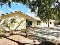 Charming single-story home with a well-maintained lawn and inviting curb appeal, nestled beneath lush trees at 110 Pine Ave, Osprey, FL 34229