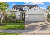 Charming home featuring a well-manicured lawn, stone accents, and a spacious two-car garage at 11420 Golden Bay Pl, Bradenton, FL 34211