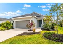 Charming single-story home featuring manicured landscaping, a two-car garage, and a welcoming entrance at 13487 Old Creek Ct, Parrish, FL 34219