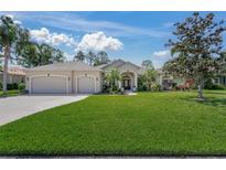 Charming single-story home featuring a three-car garage and well-manicured lawn with tropical landscaping at 14404 18Th E Pl, Bradenton, FL 34212