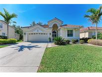 Charming single-story home featuring a well-manicured lawn, tropical landscaping and a tile roof at 322 Langholm Dr, Venice, FL 34293