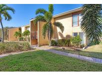 Attractive condo exterior featuring palm trees, lawn, and stucco facade in a tropical setting at 3457 Clark Rd # 156, Sarasota, FL 34231