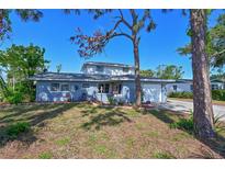 Charming two-story home features a blue exterior, well-manicured lawn, and attached garage at 404 62Nd Nw St, Bradenton, FL 34209