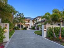 Stately home with a manicured lawn, a circular driveway, and lush tropical landscaping at 424 Bowdoin Cir, Sarasota, FL 34236
