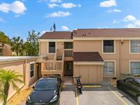 Tan townhouse with a private deck, covered entry, parking, and well-maintained landscaping on a sunny day at 6348 7Th W Ave # 6348, Bradenton, FL 34209